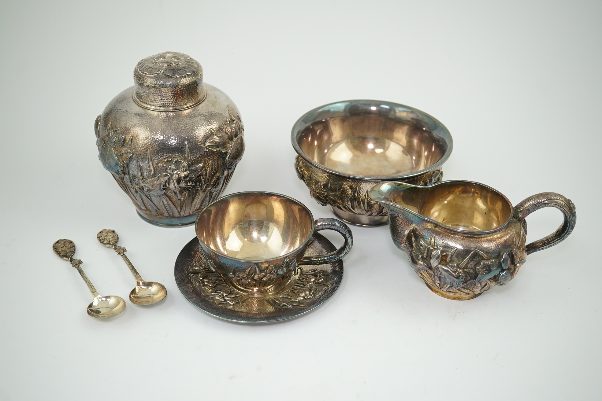 An early 20th century Japanese Meiji period planished silver matched? part tea set comprising a tea caddy with covers, sugar bowl, cream jug and tea cup and saucer